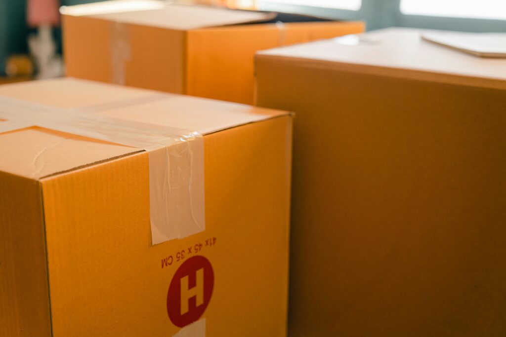 Cardboard containers sealed with sticky tape for relocation placed near window on sunny day